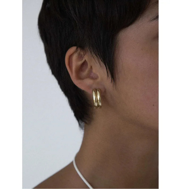 a woman casually wearing gold hoop earrings