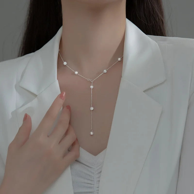 a woman wearing a silver pearl necklace