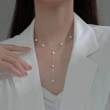 another perspective of a woman wearing a silver pearl necklace