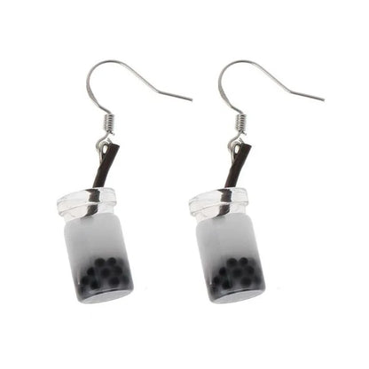 a pair of bubble tea earrings with a white liquid