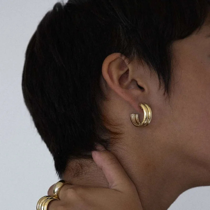 a woman wearing gold hoop earrings