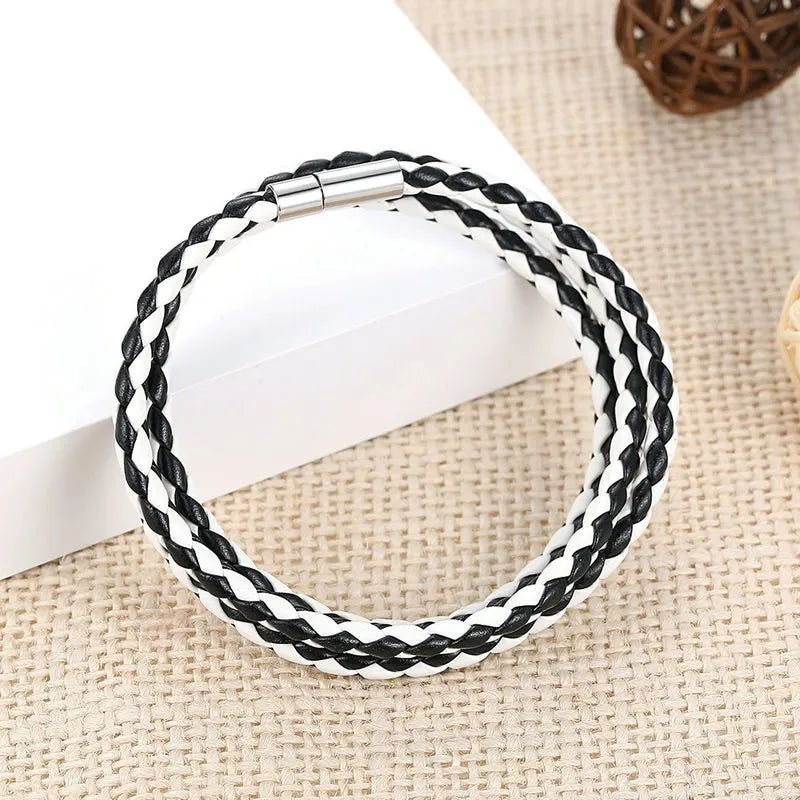 a white and black leather bracelet laying on a table. this variant is called Clear