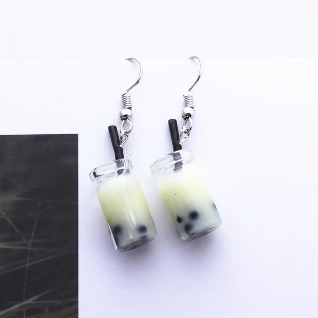 a pair of bubble tea earrings with a yellow liquid 