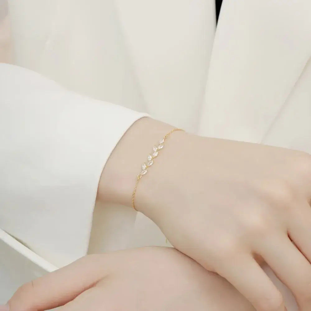 another perspective of a woman wearing a gold variant of a leaf bracelet