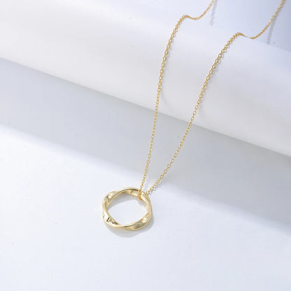 a golden necklace with a twisted ring on it