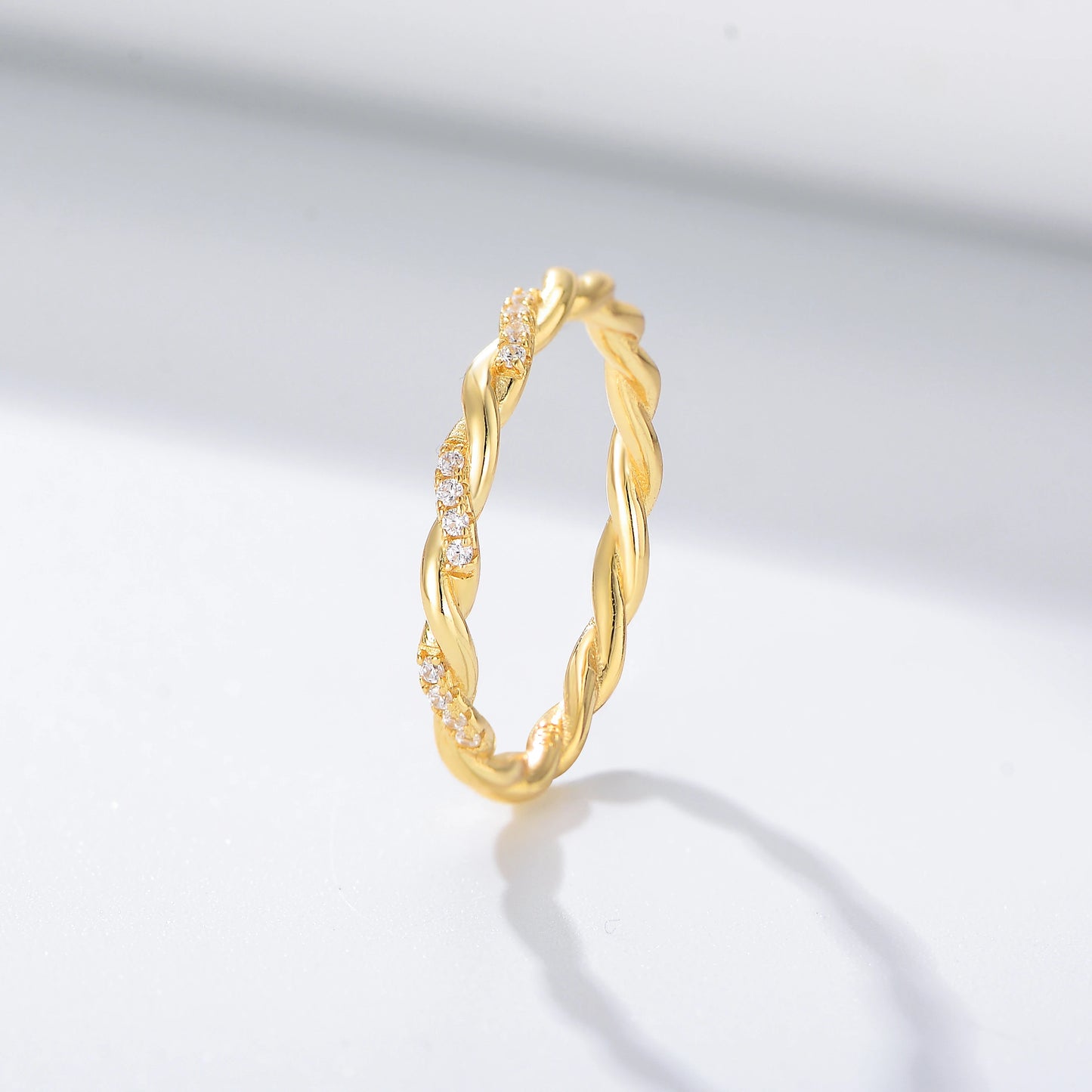 a gold twisted ring with sections of gemstones on it
