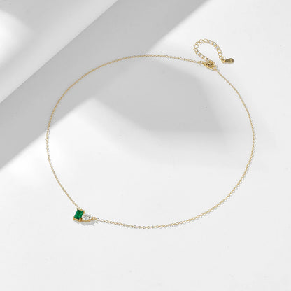 a golden necklace with a green and white gemstone on it