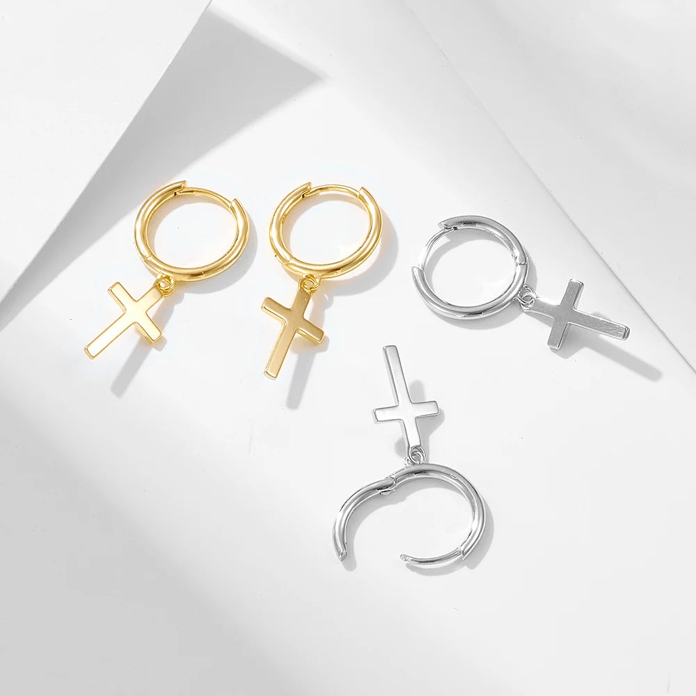 a gold and silver variant of cross earrings laying besides eachother