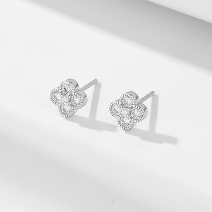 a pair of silver clover shaped earrings with gemstones set in each leaf