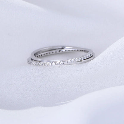 a silver ring with gemstones laying on a white surface