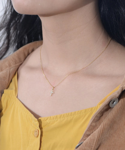 a woman wearing a golden necklace with a cross on it
