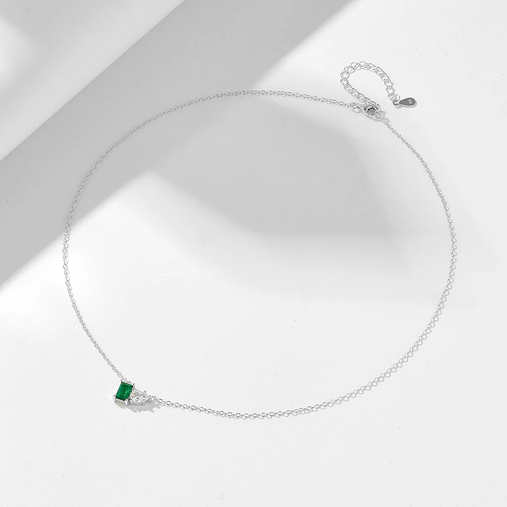 a silver necklace with a green and white gemstone on it