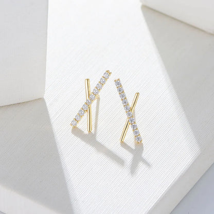 another angle of a gold X shaped earrings with gemstones on one cross