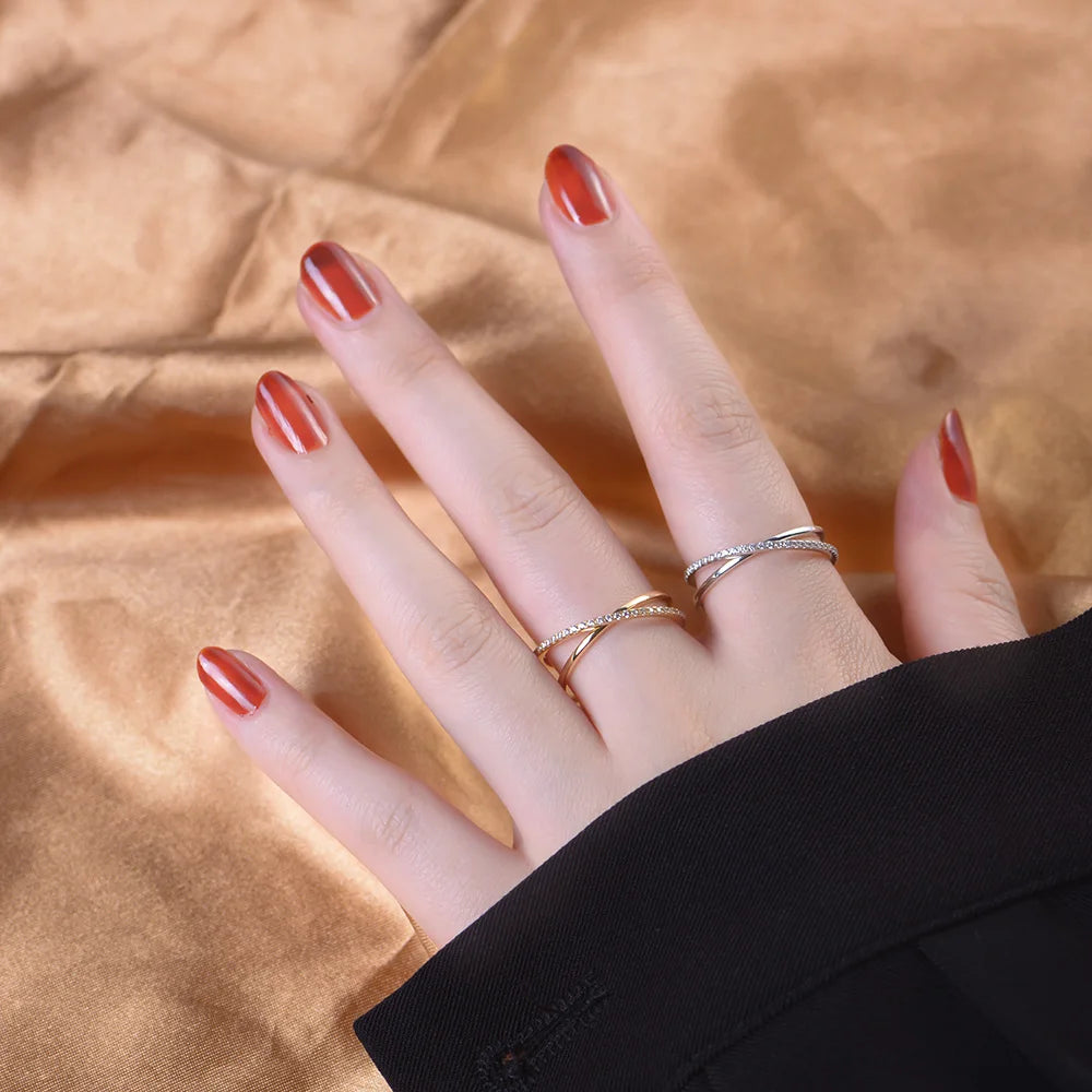 a womans hand with a golden and silver ring on her finger