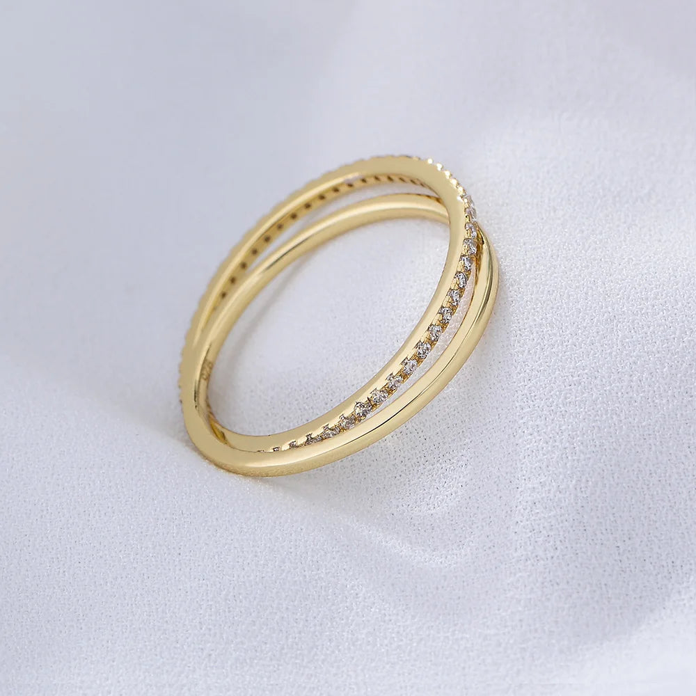 a golden ring with gemstones on it on a white surface